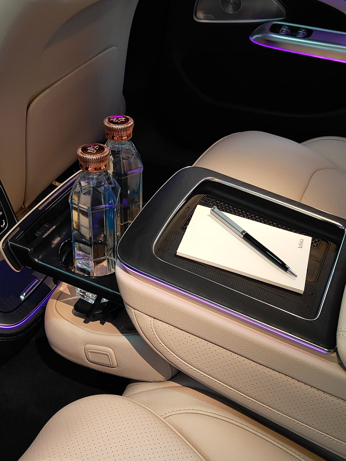 Corporate chauffeur service in Bangalore — luxury rear cabin with notepad, pen, and bottled water