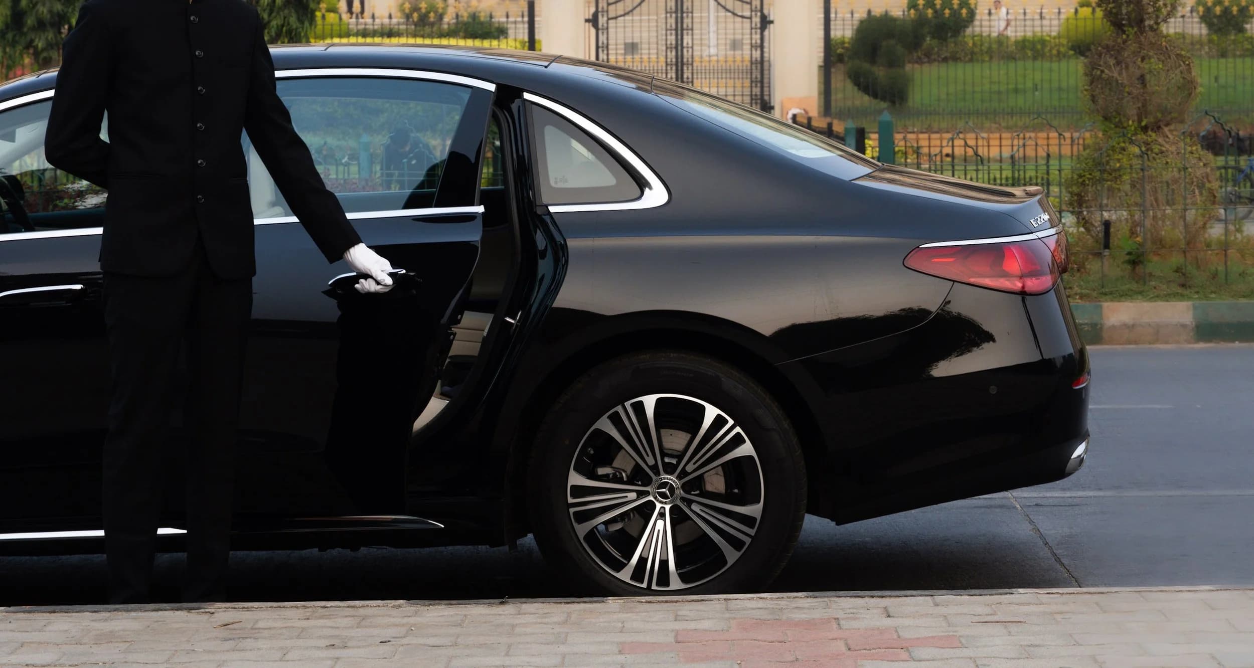 Luxury car rental in Bangalore — chauffeur opening door for executive client